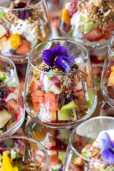 Morning tea fruit salad in clear glass displays.