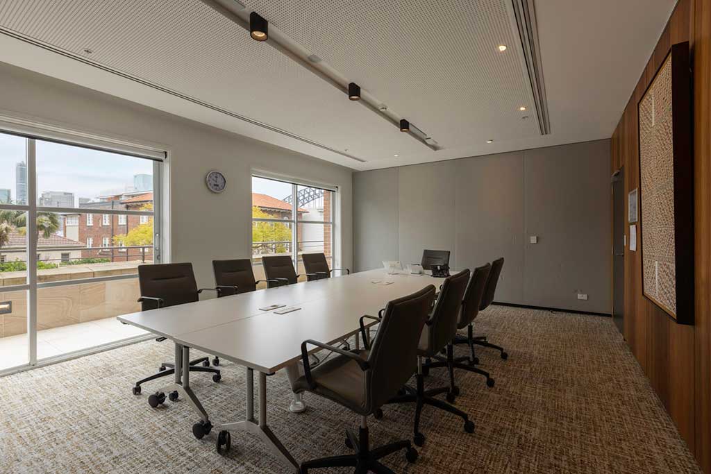 This is the level 1 conference room, setup as a boardroom with 8 chairs around. There is views to the south of the Centre towards Kirribilli Ave and artwork on the right hand side.