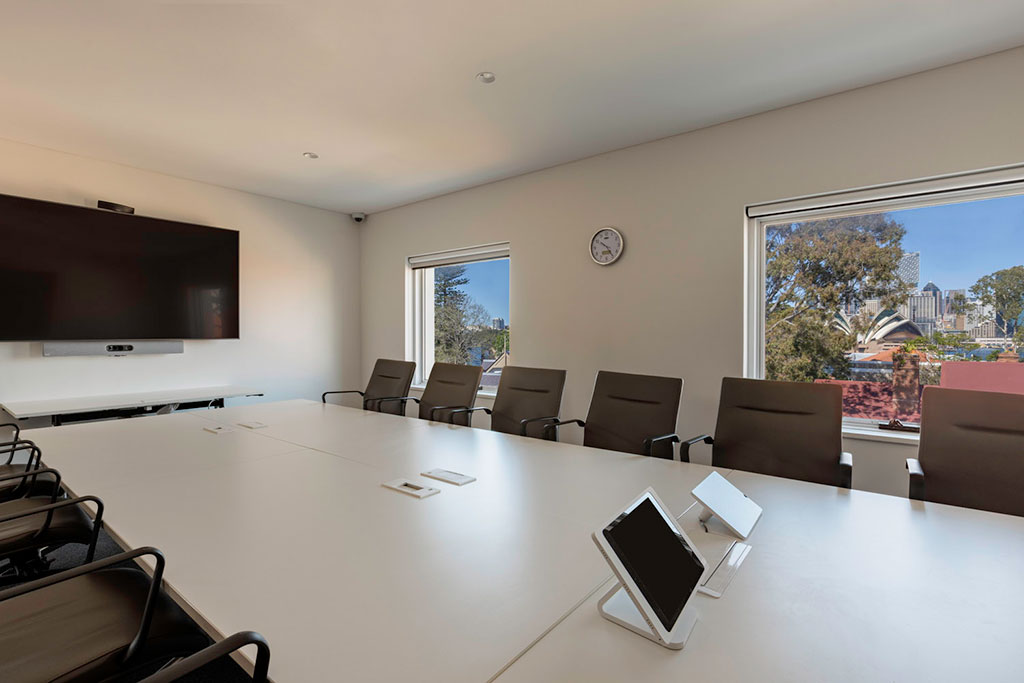 Level 3 Harbour Room setup in a boardroom style. There are IT controls on the table, presentation screen to the left and views to the south of the building towards Sydney harbour.